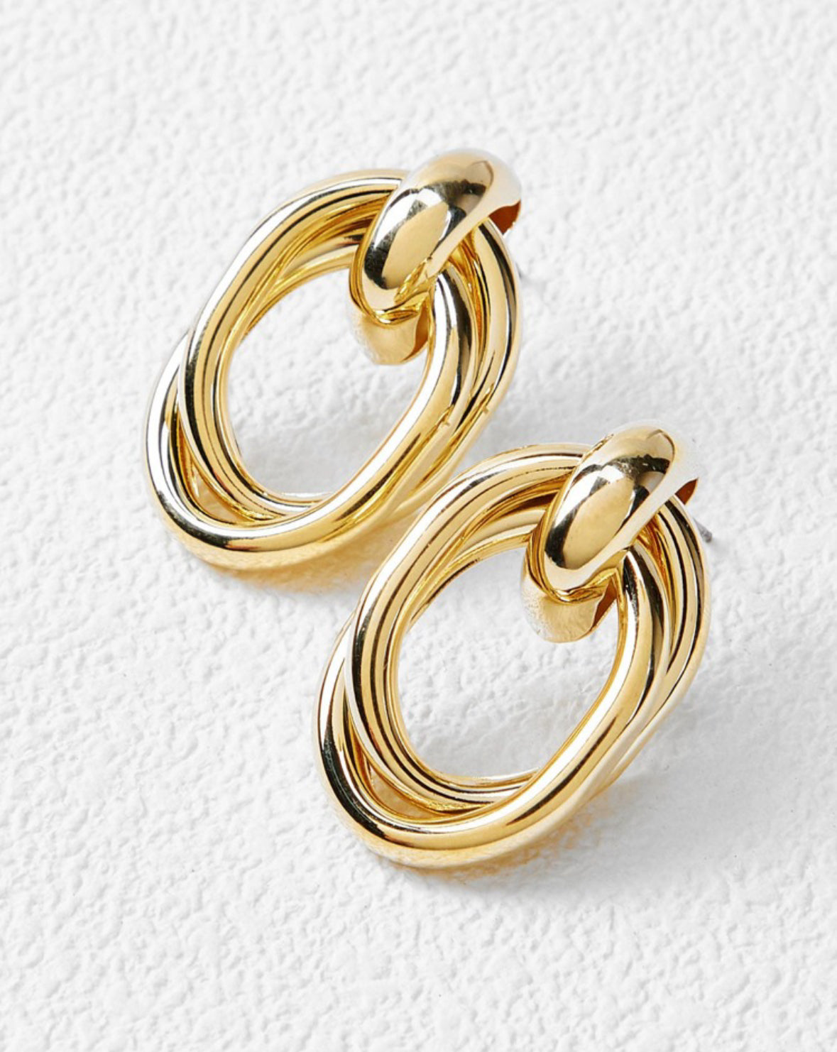 pair of gold plated earring on the white paper